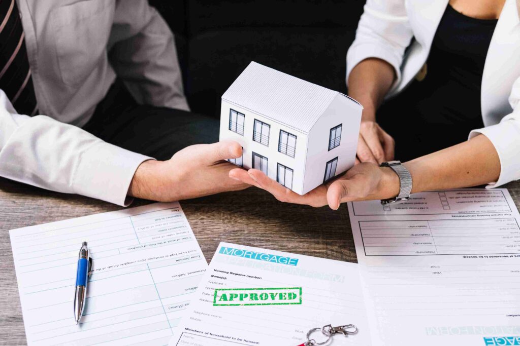 Family buying homes despite higher mortgage rates while reviewing a house purchase with a real estate agent.
